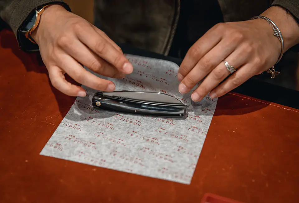 Offer a small folding knife to a woman